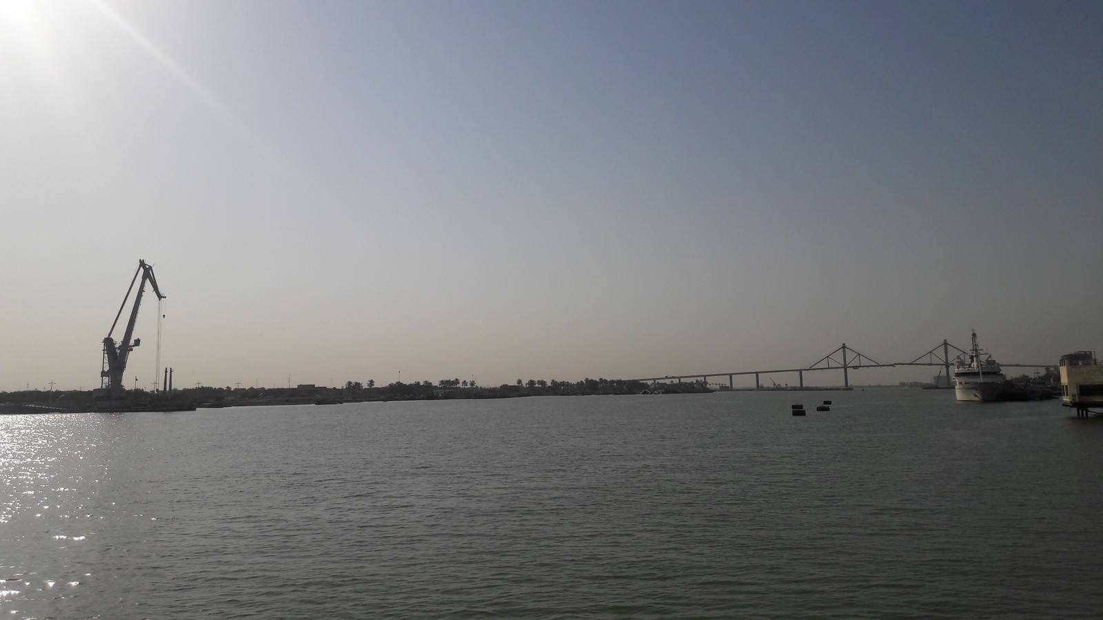The Shatt al-Arab waterway at Basra, with a bridge and port cranes in the distance
